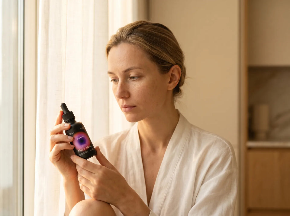 Kobieta trzyma butelkę SOMA Lion's Mane w ciepłym świetle porannym